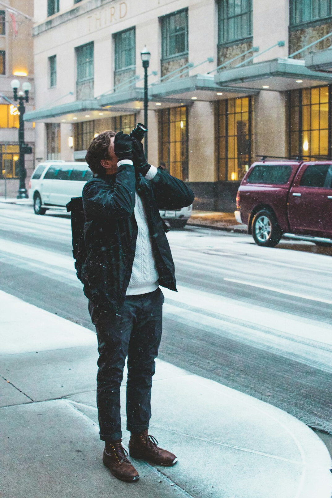 Photographer crouching to take a photo in a street scene