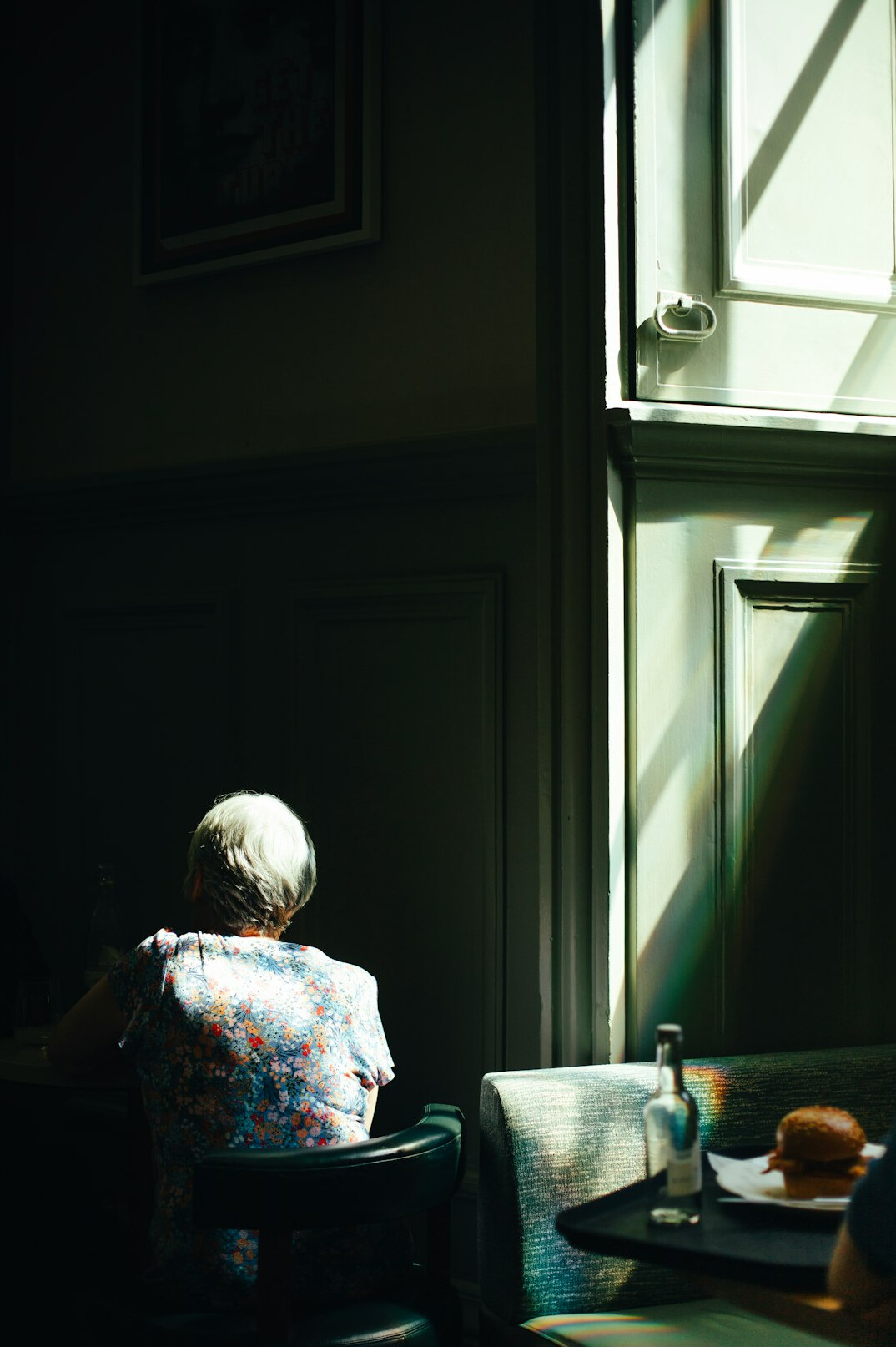 Elderly woman sitting by a window telling her story