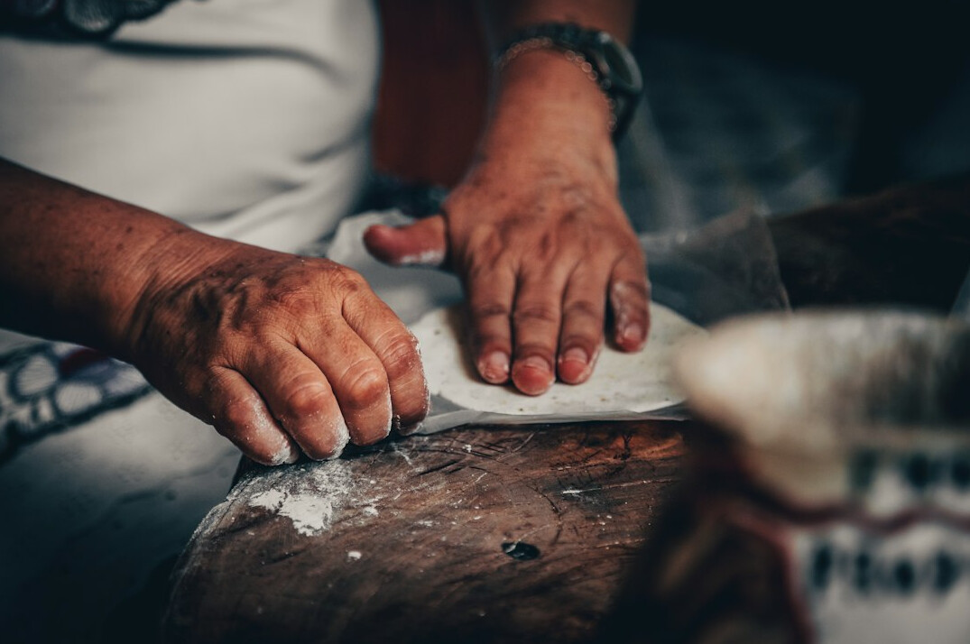 Close-up of elderly hands kneading dough